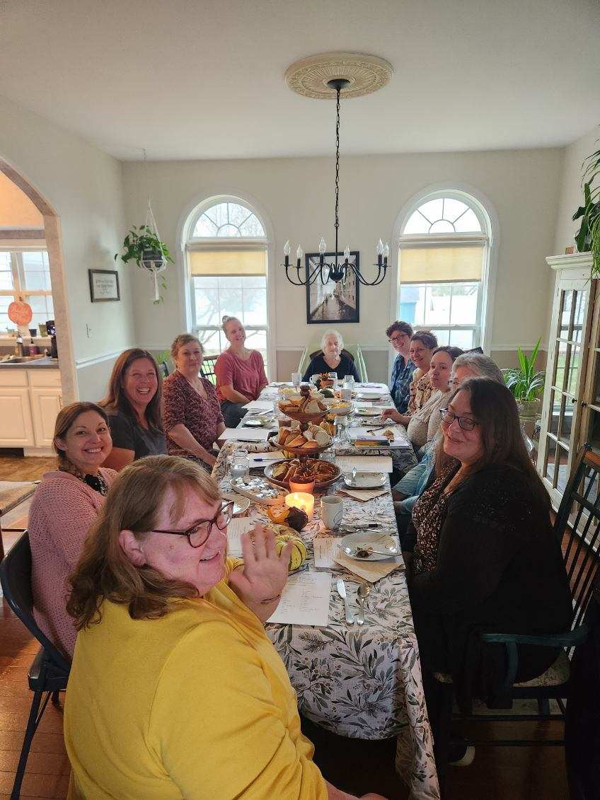 Members and guests gathered around a fellowship table